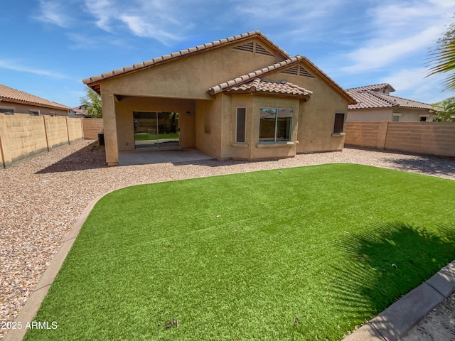 8616 S 57th Dr, Laveen, AZ 85339 - back of house with stucco siding, a fenced backyard, a lawn, and a tile roof