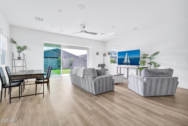 living room featuring light hardwood / wood-style flooring and ceiling fan