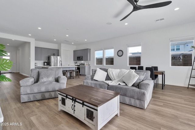 living room featuring ceiling fan and light wood-type flooring