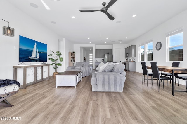 living room featuring ceiling fan and light hardwood / wood-style floors