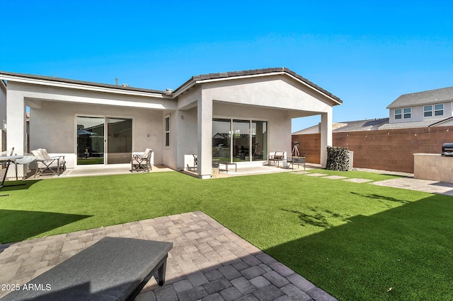 rear view of house featuring a yard and a patio area