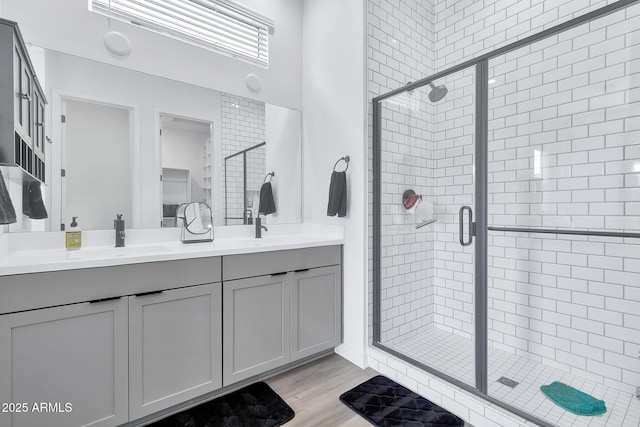 bathroom with vanity, hardwood / wood-style flooring, and a shower with shower door