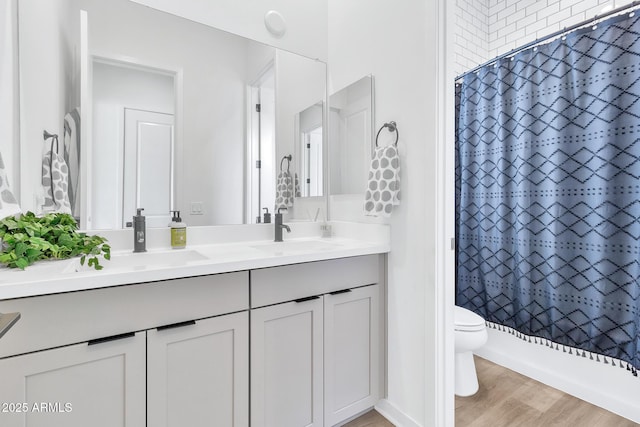 full bathroom featuring vanity, hardwood / wood-style floors, toilet, and shower / bath combo