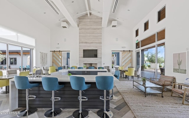 kitchen featuring a towering ceiling, a barn door, and a kitchen breakfast bar