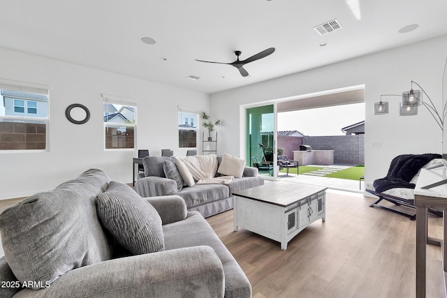 living room with light hardwood / wood-style floors and ceiling fan