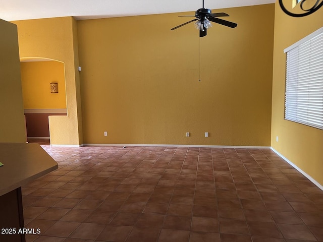 tiled spare room with ceiling fan