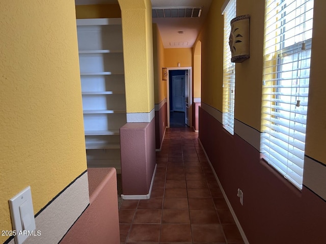 hallway with dark tile patterned flooring and built in features