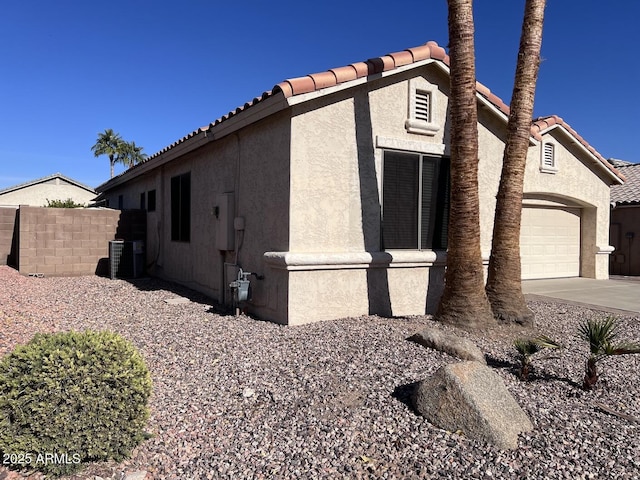 view of home's exterior with central air condition unit and a garage