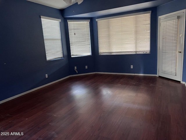 empty room with ceiling fan, vaulted ceiling, and hardwood / wood-style flooring