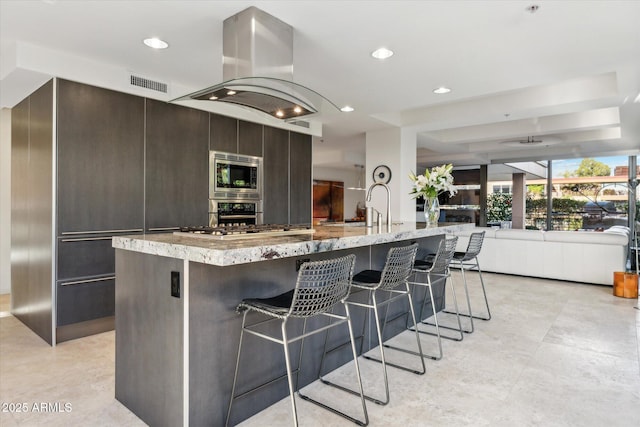 kitchen featuring a kitchen breakfast bar, appliances with stainless steel finishes, modern cabinets, and visible vents