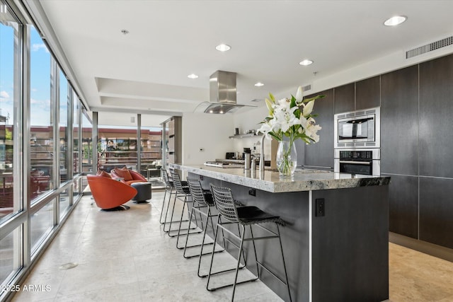 kitchen featuring visible vents, island range hood, stainless steel appliances, and a healthy amount of sunlight
