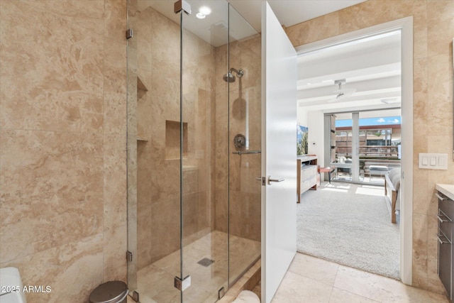 ensuite bathroom featuring tile patterned floors, ensuite bath, and a shower stall