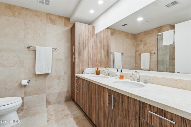 full bathroom featuring toilet, visible vents, and a sink