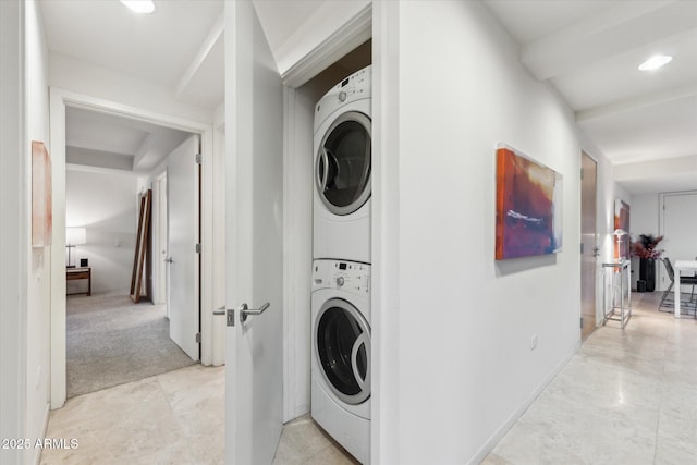 washroom with recessed lighting, stacked washer and dryer, and baseboards