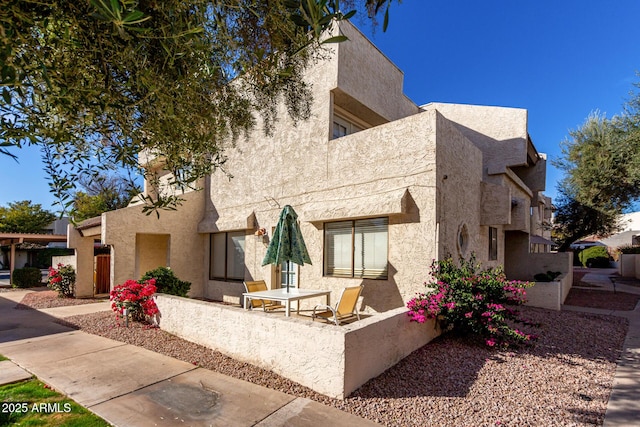 view of front facade featuring a balcony and stucco siding