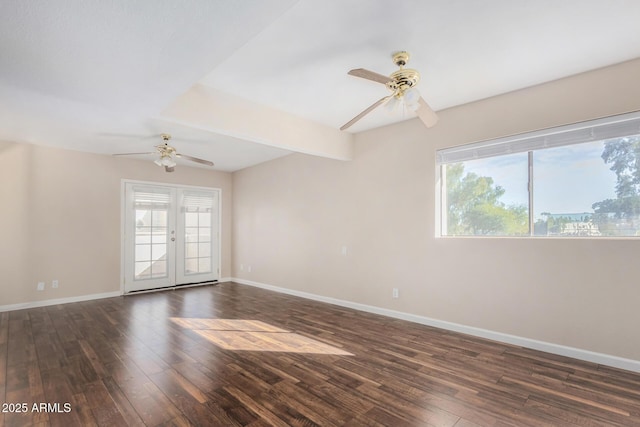 empty room featuring a healthy amount of sunlight, baseboards, dark wood-style flooring, and french doors