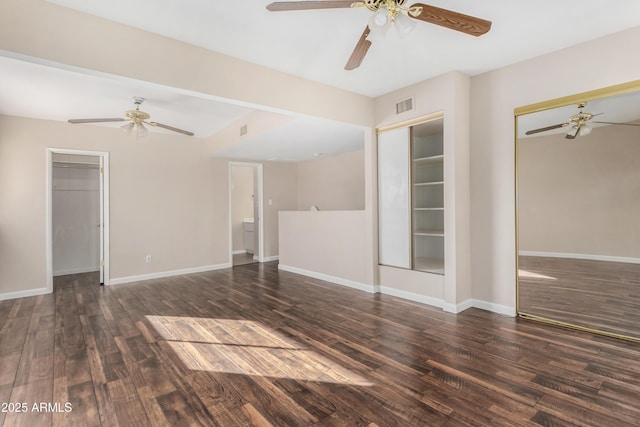 empty room with wood finished floors, visible vents, and baseboards