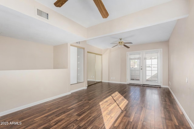 empty room with visible vents, baseboards, ceiling fan, and dark wood-style flooring