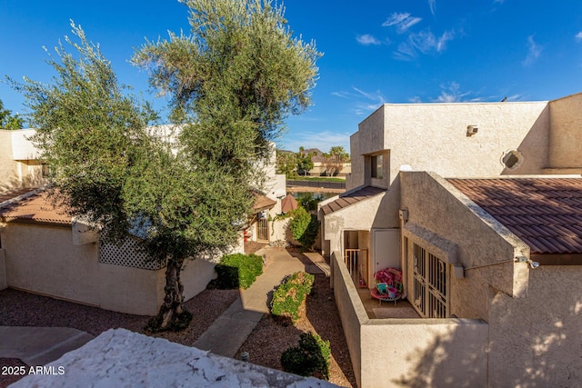 view of property exterior with a residential view, a patio area, and stucco siding