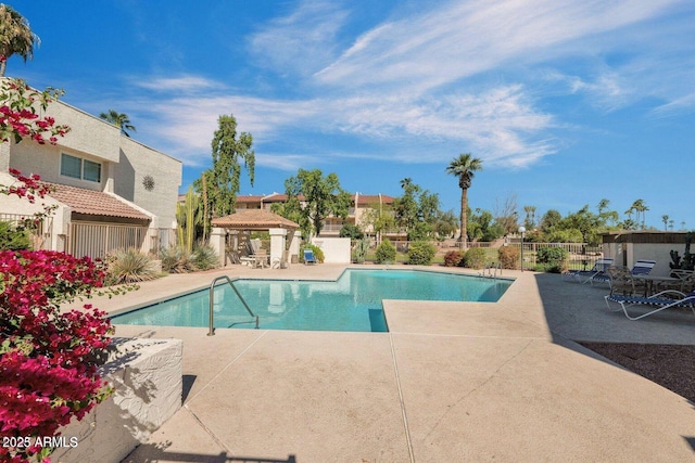 pool with a gazebo, a patio, and fence