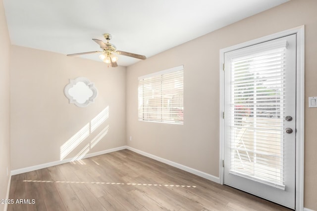 entryway with ceiling fan, wood finished floors, and baseboards