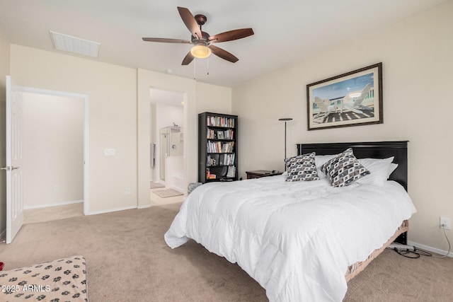 bedroom featuring connected bathroom, light colored carpet, and ceiling fan