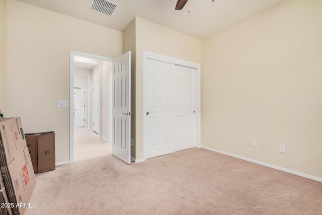 unfurnished bedroom featuring light colored carpet and ceiling fan