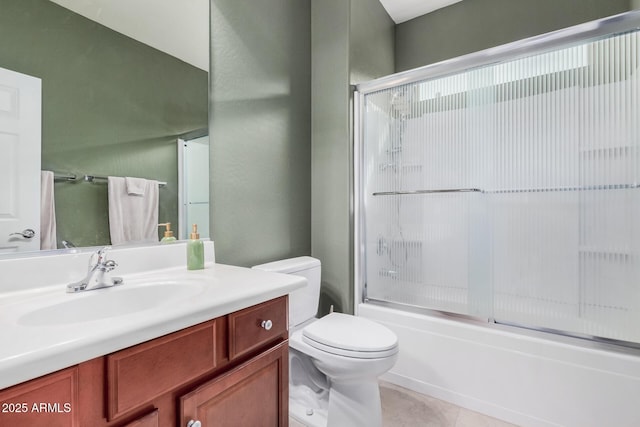 full bathroom featuring vanity, tile patterned floors, shower / bath combination with glass door, and toilet