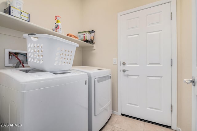 laundry area with light tile patterned flooring and washer and clothes dryer