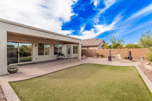 back of house with a patio, ceiling fan, and a lawn