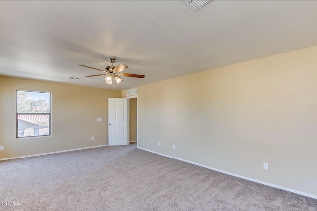 unfurnished room with a ceiling fan, carpet flooring, visible vents, and baseboards