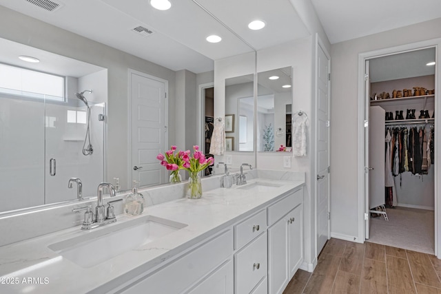 bathroom featuring hardwood / wood-style flooring, vanity, and an enclosed shower