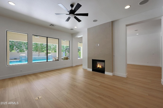 2859 E Los Altos Rd, Gilbert, AZ 85297 - unfurnished living room with a fireplace, light wood-type flooring, recessed lighting, and a ceiling fan