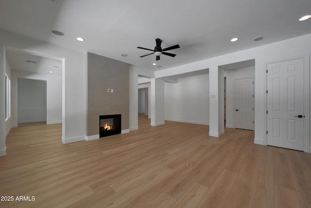2859 E Los Altos Rd, Gilbert, AZ 85297 - unfurnished living room with ceiling fan, light wood-style flooring, a lit fireplace, and recessed lighting