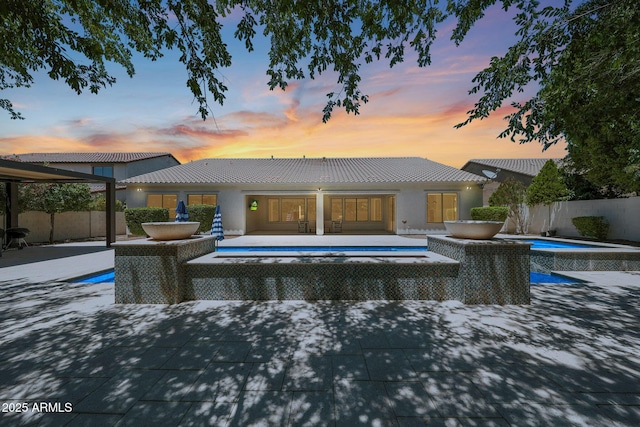 2859 E Los Altos Rd, Gilbert, AZ 85297 - pool at dusk with a hot tub, a patio area, and a fenced backyard