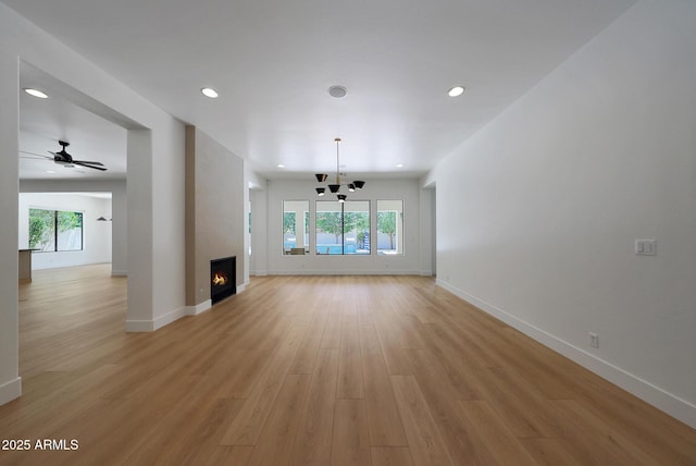 2859 E Los Altos Rd, Gilbert, AZ 85297 - unfurnished living room with light wood-style floors, healthy amount of natural light, a chandelier, a large fireplace, and recessed lighting