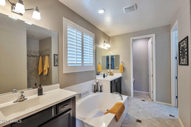 bathroom featuring tile patterned floors, a garden tub, visible vents, and a sink