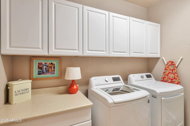 clothes washing area with washing machine and clothes dryer and cabinet space