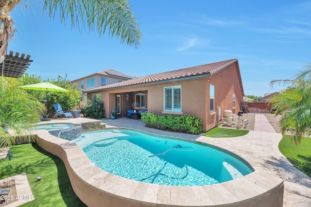 view of pool featuring a pool with connected hot tub, fence, and a patio