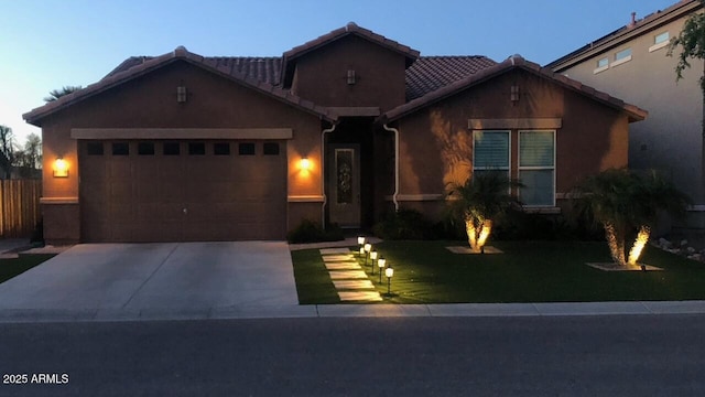view of front of home featuring a garage, stucco siding, driveway, and a front lawn