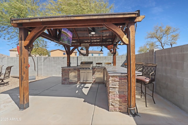 view of patio / terrace with a gazebo, area for grilling, outdoor wet bar, and a fenced backyard