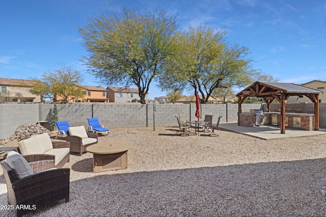 view of yard featuring an outdoor living space, a fenced backyard, a gazebo, exterior kitchen, and a patio area