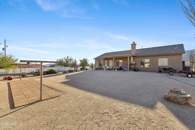 rear view of property with fence and a chimney