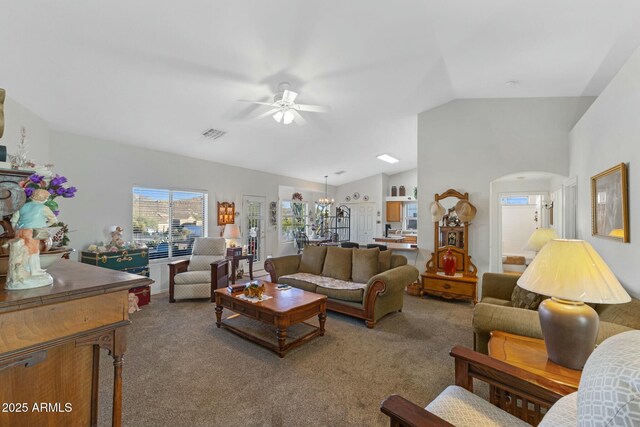 carpeted living room featuring lofted ceiling, visible vents, arched walkways, and a ceiling fan