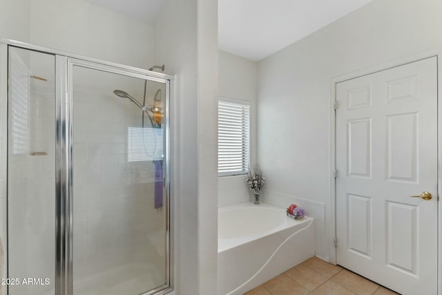 full bathroom featuring a stall shower, a garden tub, and tile patterned floors