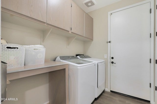 clothes washing area featuring light hardwood / wood-style floors, cabinets, and washer and dryer