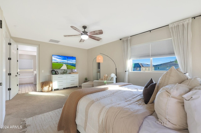 carpeted bedroom featuring ceiling fan and ensuite bath