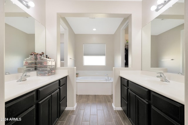 bathroom featuring a washtub, vanity, and hardwood / wood-style flooring