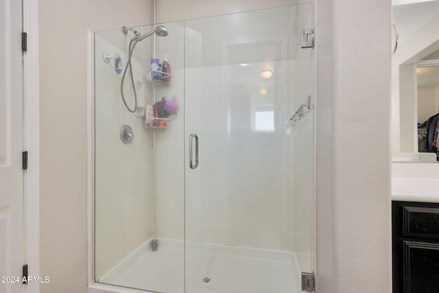 bathroom featuring walk in shower and vanity