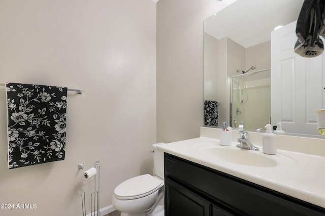 bathroom with an enclosed shower, vanity, and toilet